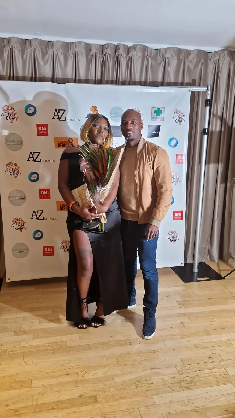 Lauréate avec son bouquet devant le photocall à l’Afro Gala 2023, aux Terrasses du Parc à Villeurbanne