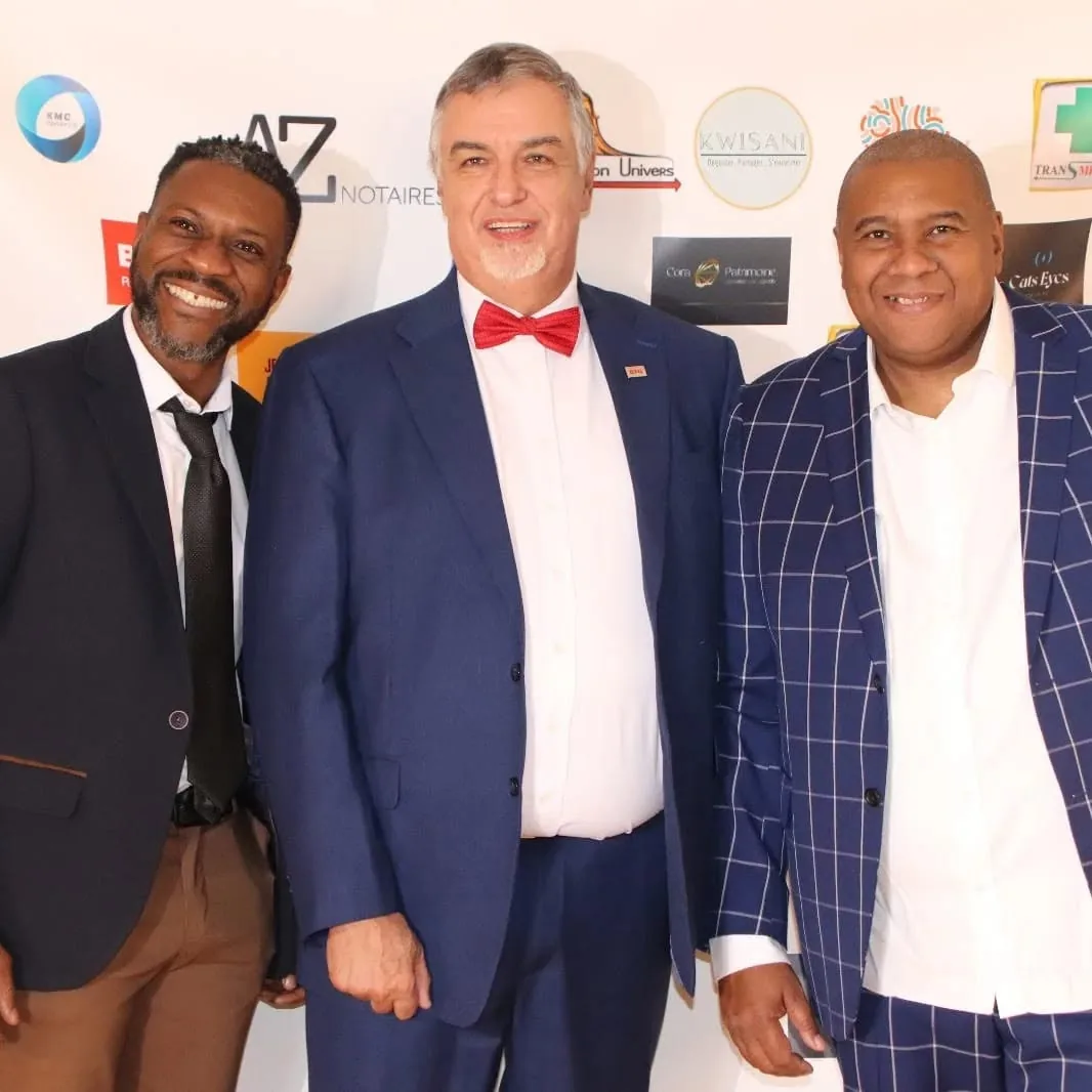 Trois invités devant le mur des partenaires à l’Afro Gala 2023, aux Terrasses du Parc à Villeurbanne