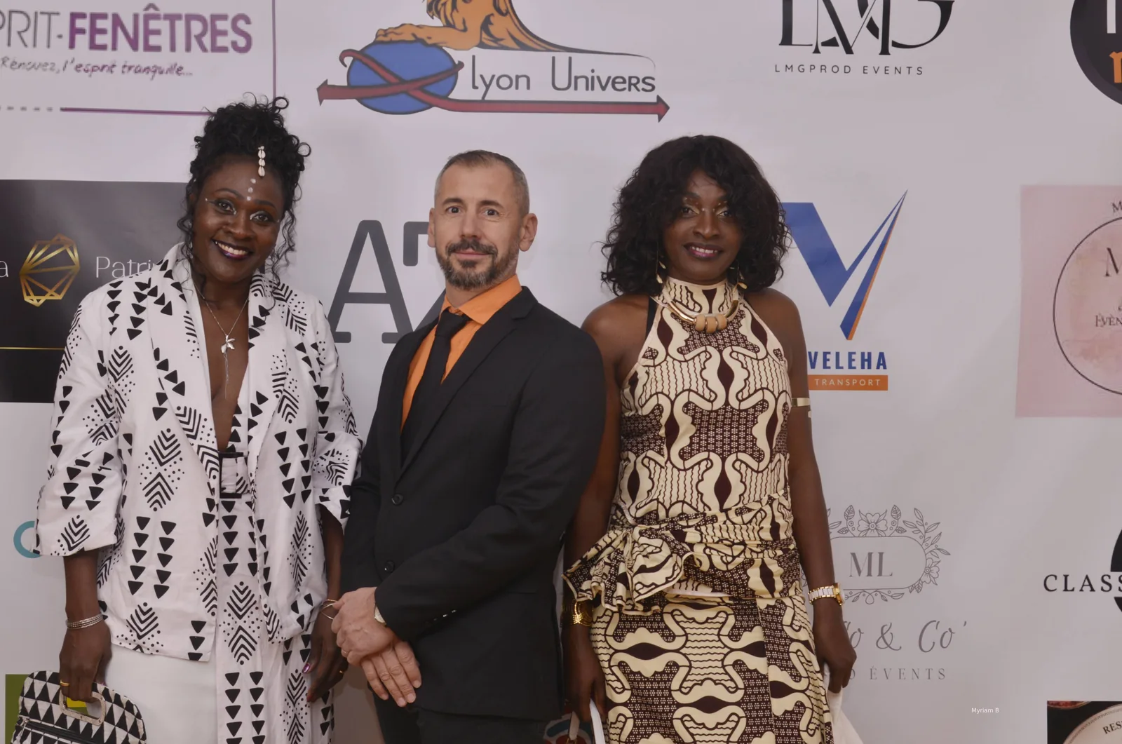 Invités posés devant le mur des partenaires à l’Afro Gala 2025, aux Terrasses du Parc à Villeurbanne
